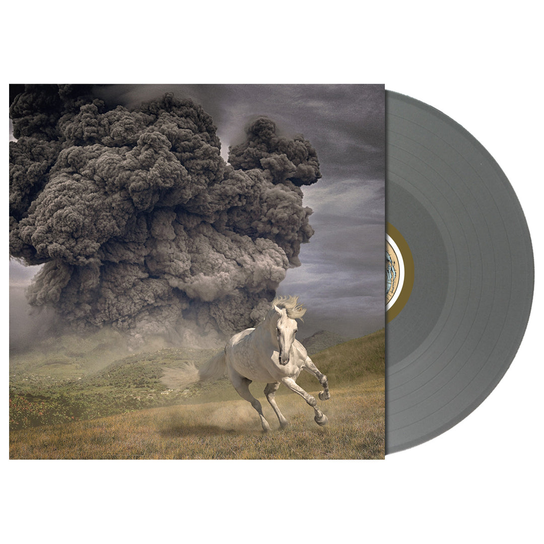 A vinyl record by The White Buffalo, partially out of its sleeve for the album Life Goes On, shows artwork of a white horse fleeing a dark smoke cloud over grass beneath a stormy sky. Track list details are visible.