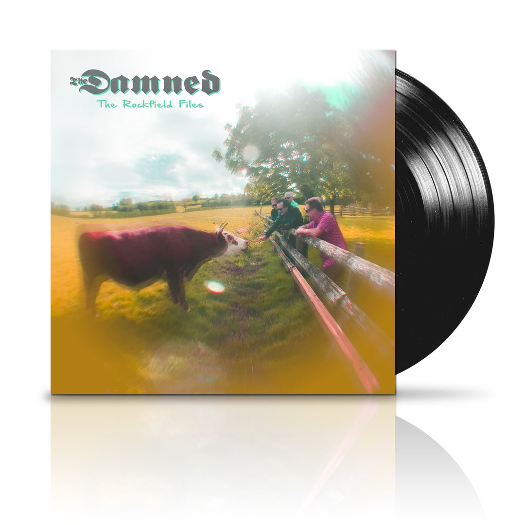 The Damneds The Rockfield Files album cover shows a blurred photo of two people on a fence in a field with a nearby cow, echoing Black Is The Night. A vinyl record is partially visible next to the album. Brand: The Damned.