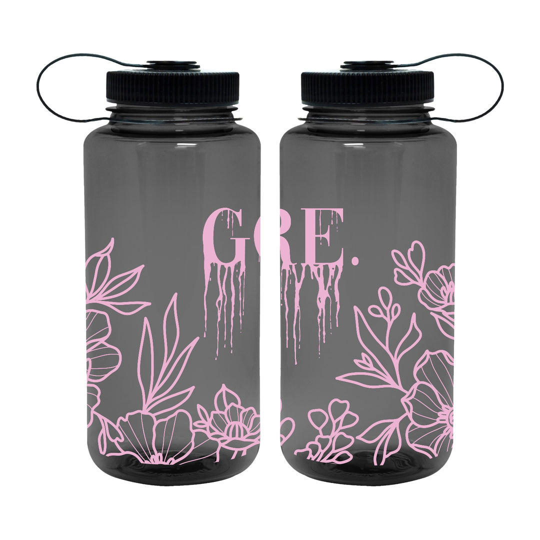 Two dark translucent Gore. bottles with black lids, featuring a light pink floral logo at the bottom and GRE. in pink paint drip lettering on the front.