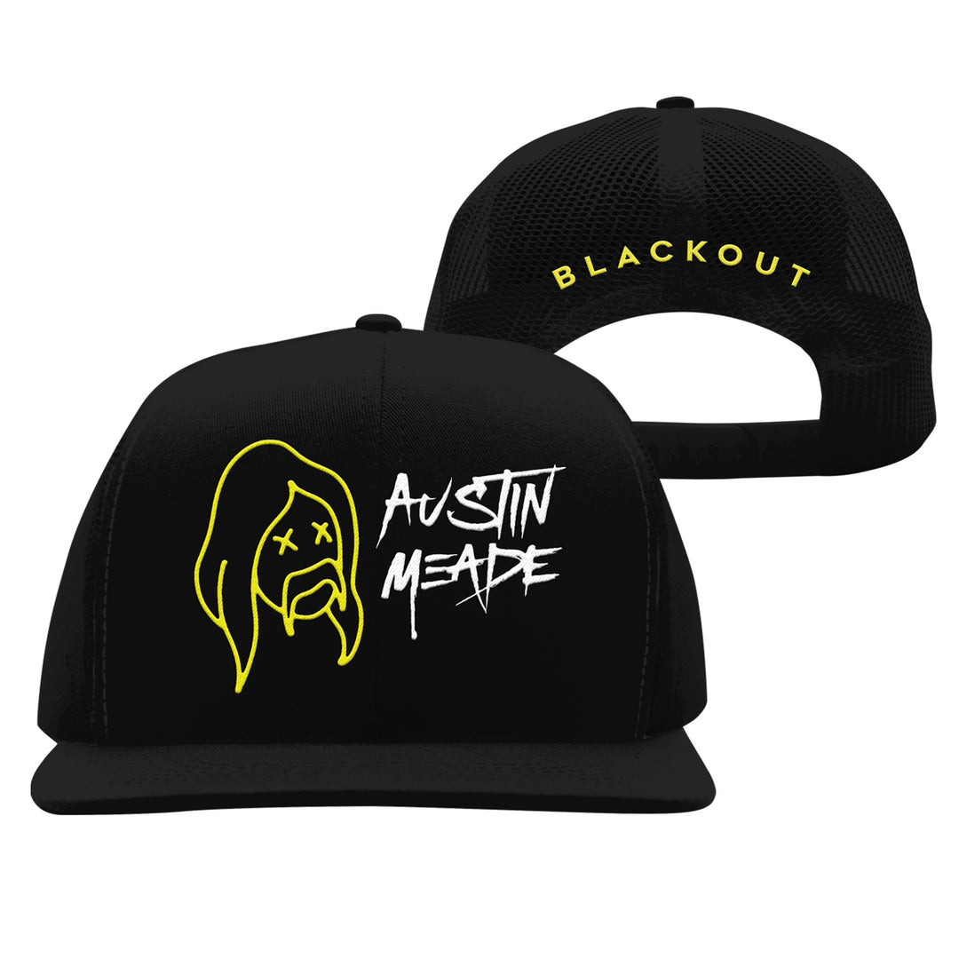 Two black Austin Meade snapback hats with a yellow outline of a bearded face with X eyes and AUSTIN MEADE in white graffiti on the front; BLACKOUT in bold yellow on the back.