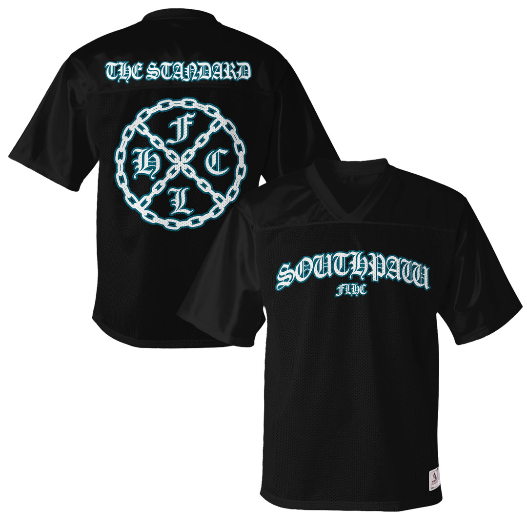 Southpaw FLHC black mesh short-sleeve replica football jersey with gothic blue SOUTHPAW FWC on front, THE STANDARD above a circular chain graphic with F C H L C on back. Inspired by classic men's stadium jerseys.