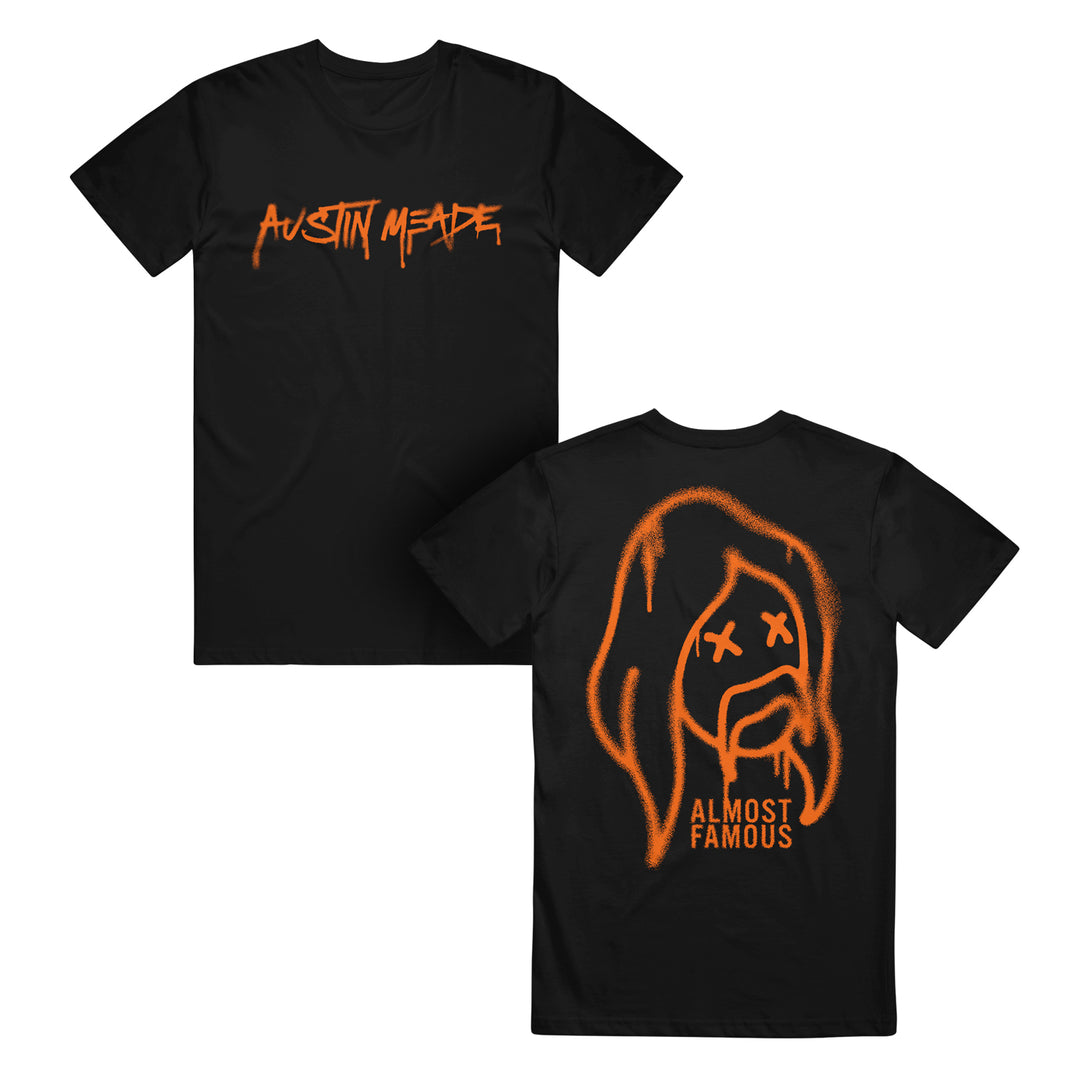 Black streetwear t-shirt by Austin Meade featuring bold, orange, graffiti-style lettering across the chest.
Black t-shirt from Austin Meade featuring a graffiti face with orange spray-painted, long-haired design, Xs for eyes, and “ALMOST FAMOUS” text on the back—ideal for an edgy streetwear vibe.