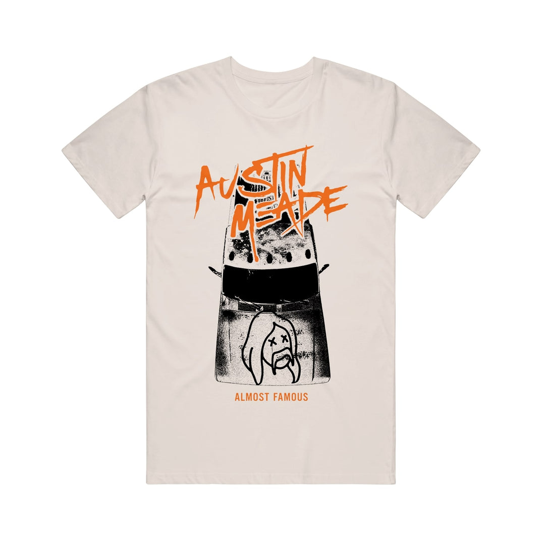 Austin Meade natural white t-shirt with bold orange Austin Meade text, a black-and-white dog illustration with Xs for eyes, pickup truck motif, and Almost Famous below the design.
