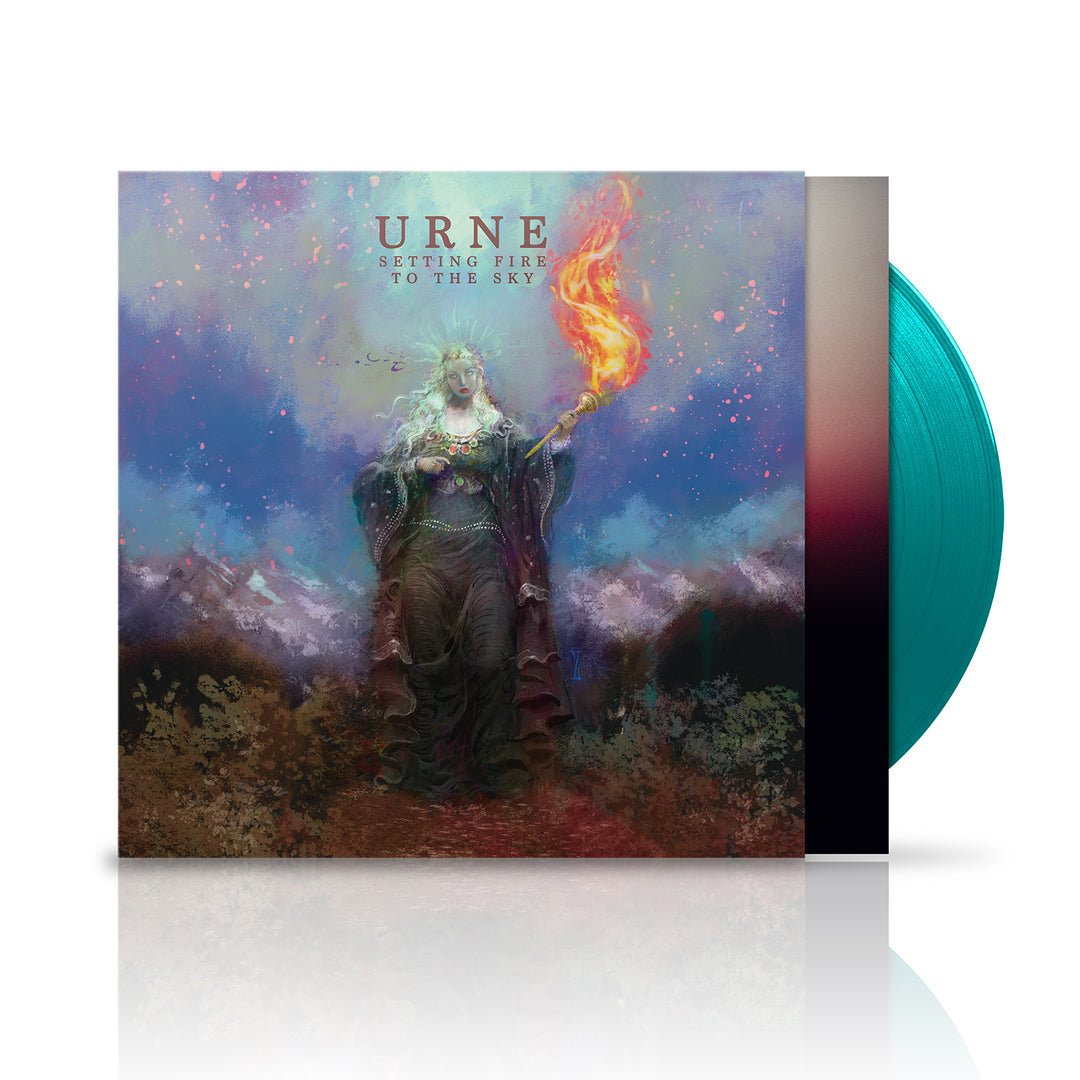 A blue-green vinyl by Urne lies beside its cover, featuring a mystical figure with a flaming torch under a vibrant sky and mountains. “Setting Fire to the Sky” and “The Spirit Alive” are displayed above.