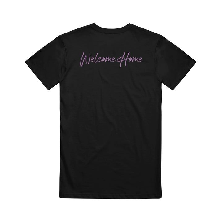 VRSTY black t-shirt featuring Welcome Home in bold purple script across the upper back.