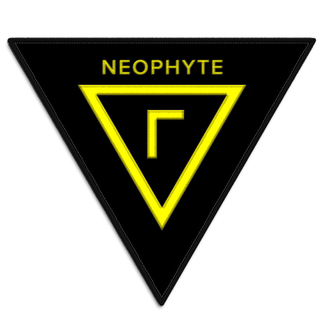 A black Shining patch with a yellow outlined triangle, NEOPHYTE at the top, and a yellow geometric symbol resembling an upside-down L in the center.