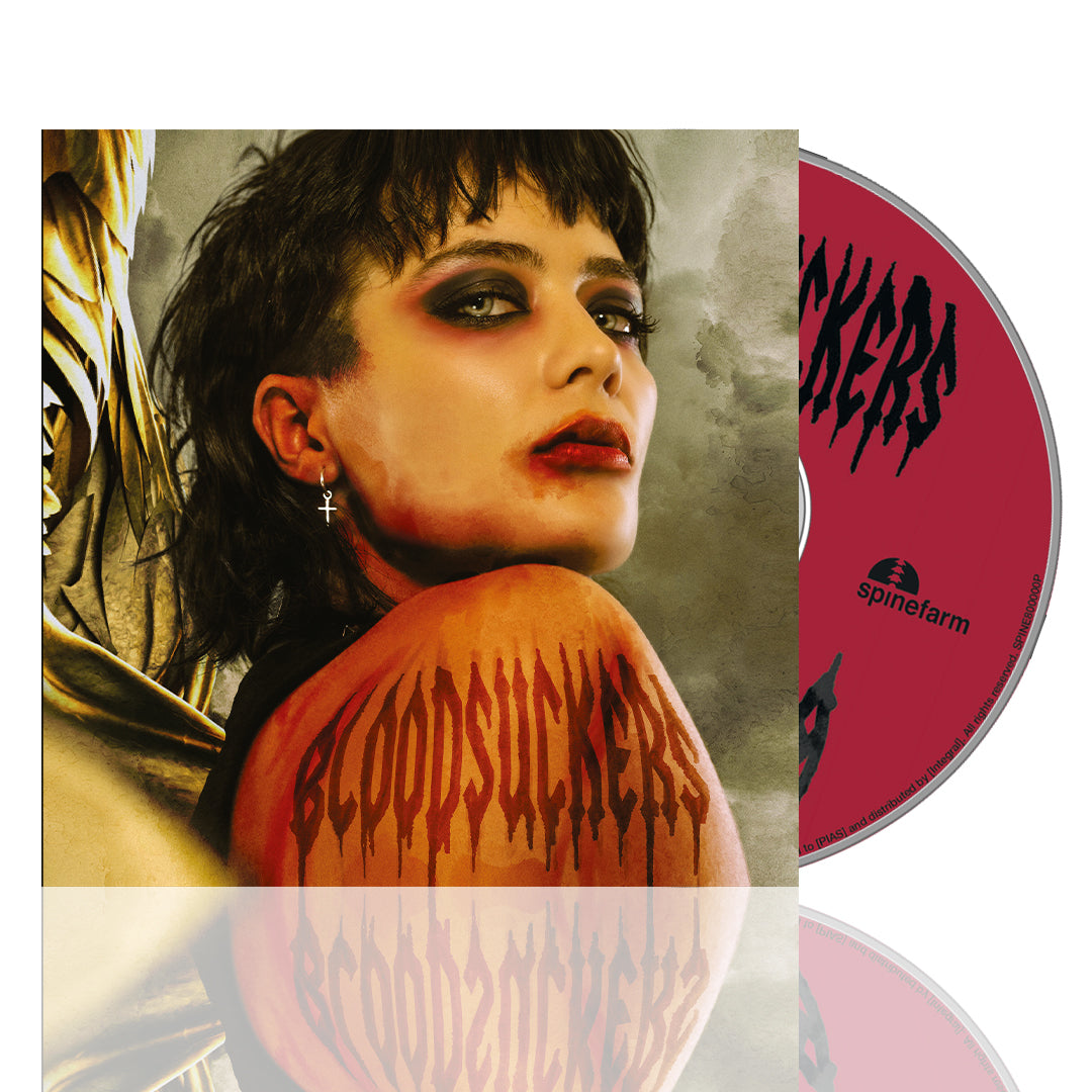 A CD cover from Saint Agnes shows a person with dramatic makeup and short dark hair, glancing over their shoulder. "BLOODSUCKERS" in red, dripping letters appears on their arm, and the partially visible CD promises an electrifying release.