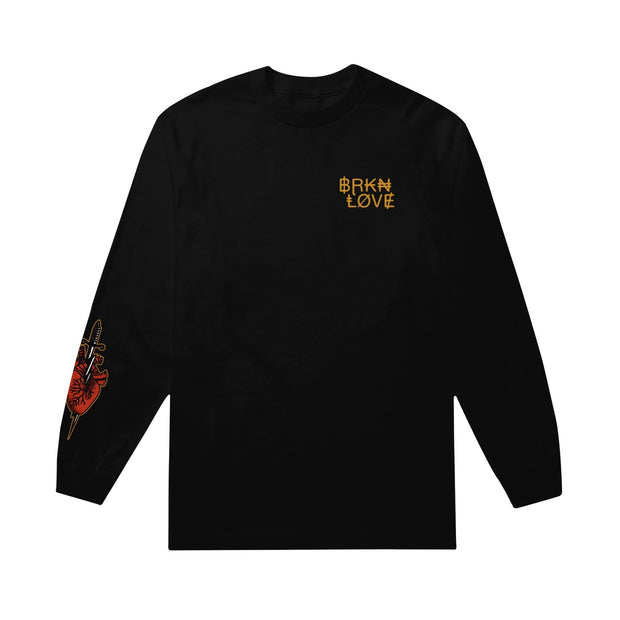 image of a black long sleeve tee shirt on a white background. tee has small right chest print in gold that says broken love. bottom left sleeve has print of a heart with a dagger through it