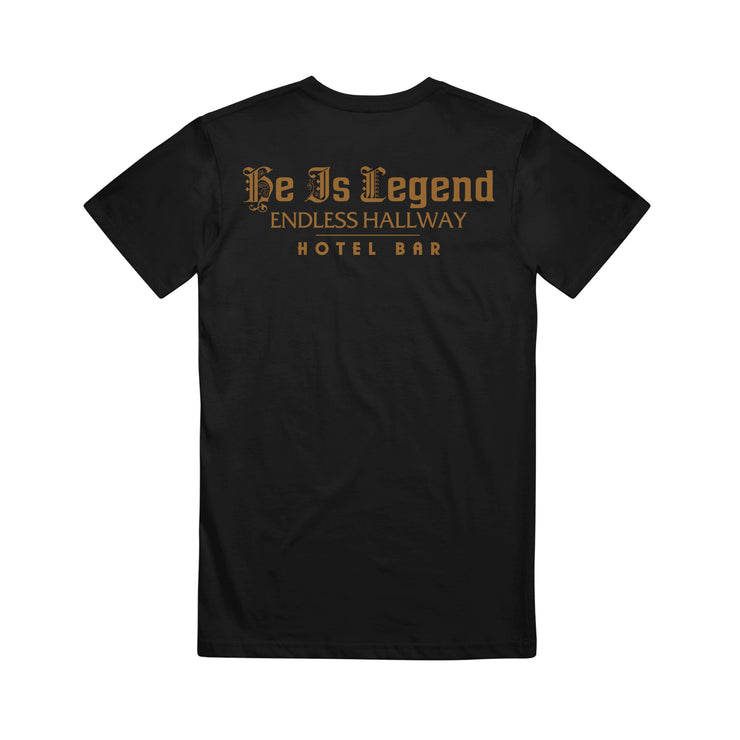 image of the back of a black tee shirt on a white background. tee  has a gold print across the shoulders that says he is legend endless hallway hotel bar