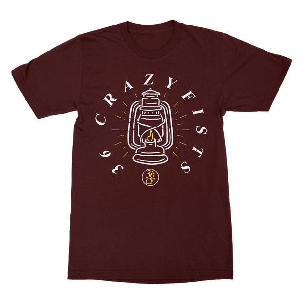 image of a maroon tee shirt on a white background. tee has center chest print of a lantern. around the lantern says 36 crazyfists